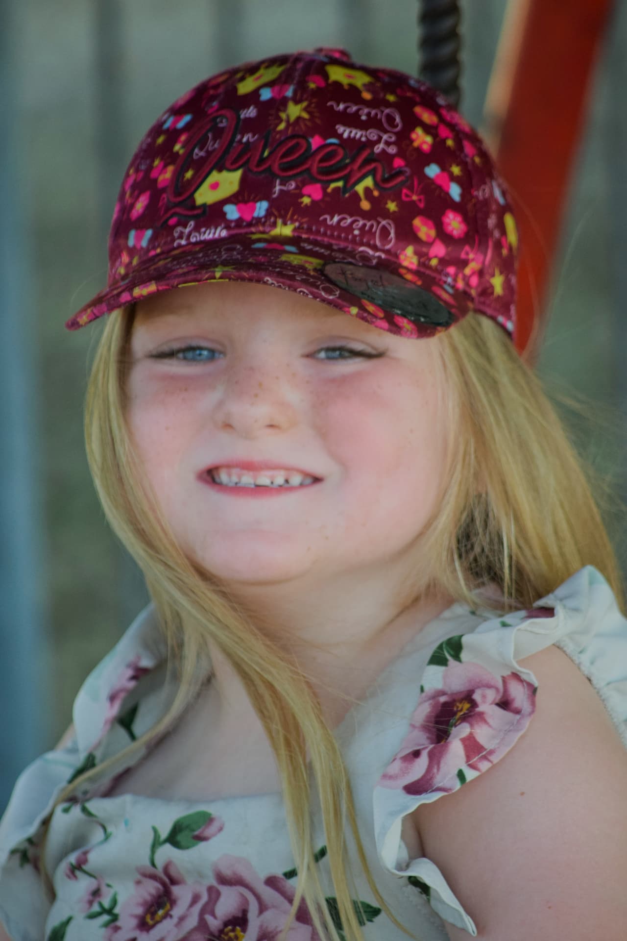 Young girl in a pink cap smiling in the sunshine